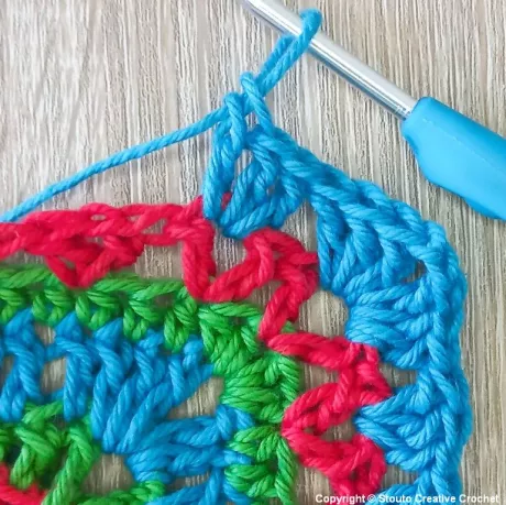 Round 10 of African flower crochet square building solid stitch groups