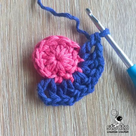Round 2 of the Bold Buttercup flower crochet square showing increases and chain spaces
