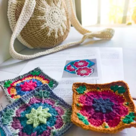 granny squares in foreground crossbody bag in background