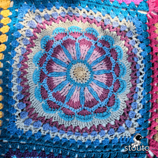 African patchwork crochet flower square showing bold color contrast and petal detail