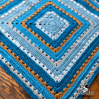 Easy one-square growing crochet blanket worked from the centre outward