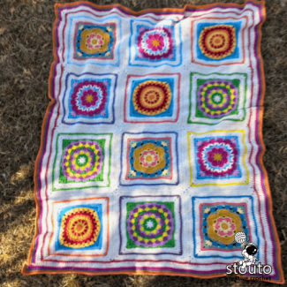 Four large crochet flower squares in the Boxed Flower blanket design