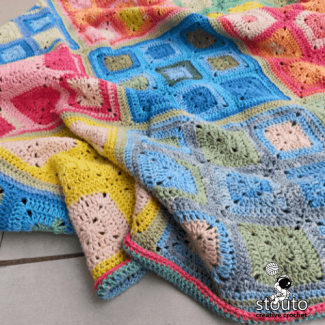 Colorful crochet granny square blanket made from mixed rainbow yarn shades