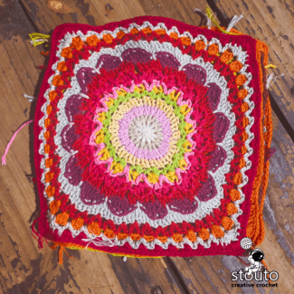 Crochet flower patchwork blanket square detail with textured stitches and bright colors
