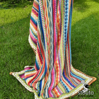 Crochet stitch sampler blanket created with bold and vibrant yarn colours