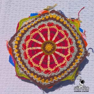 Large floral crochet granny square texture with layered petals and bold color contrast