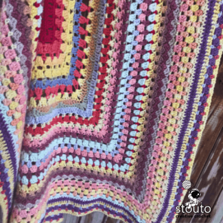 Modern scrap yarn baby blanket design with a fresh twist on a classic style