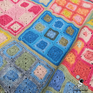 Rainbow granny square blanket layout showing vibrant patchwork arrangement