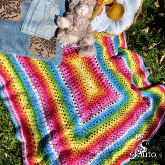 Vibrant striped crochet blanket in rainbow color sequence