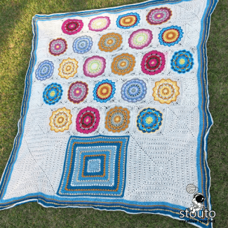 Large granny square crochet blanket with flower-inspired squares.