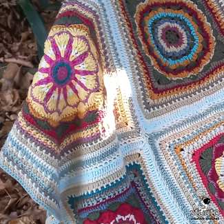 Daisy Style textured granny square crochet pattern featuring a raised flower center and decorative border.