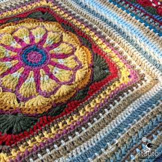 Free crochet pattern for a daisy-inspired textured granny square suitable for blankets, cushions, and bags.