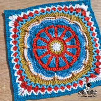 Close-up of the TMBJGF Flower Granny Square showing raised flower petals and textured crochet stitches.