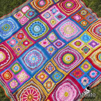 Hand crocheting a flower granny square with multi-coloured yarn