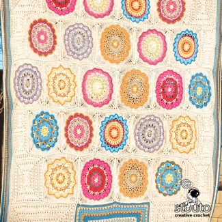 Patchwork crochet blanket pattern using multiple granny square designs.