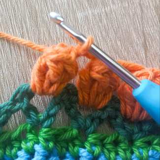 Secure with sc stitch, then ch2, after popcorn stitch is complete.