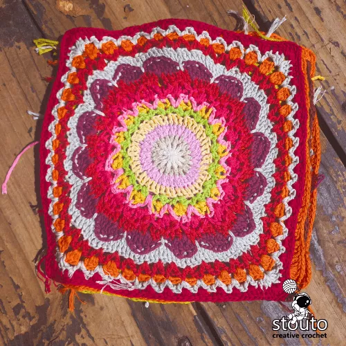 Crochet flower patchwork blanket square detail with textured stitches and bright colors