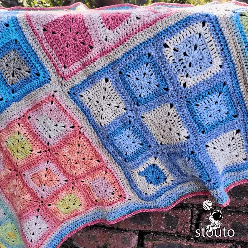 Easy granny square blanket in rainbow patchwork design with bright colorful squares