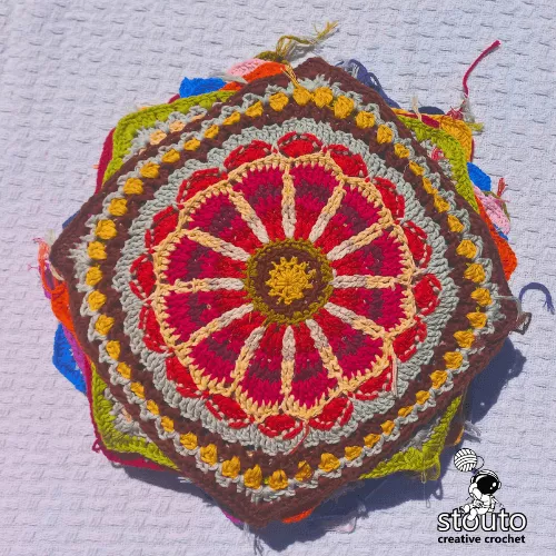 Large floral crochet granny square texture with layered petals and bold color contrast