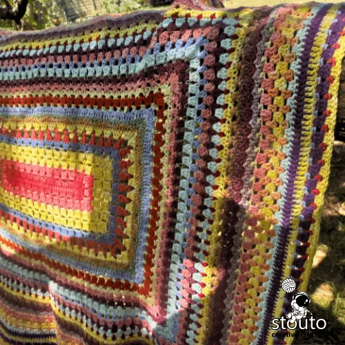 Stash-busting crochet baby blanket made from yarn scraps and leftover yarn
