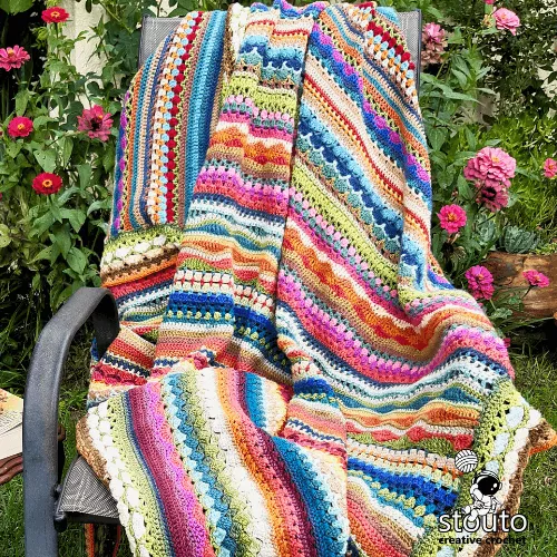 Close-up detail of crochet stitch sampler blanket showing textured stitches
