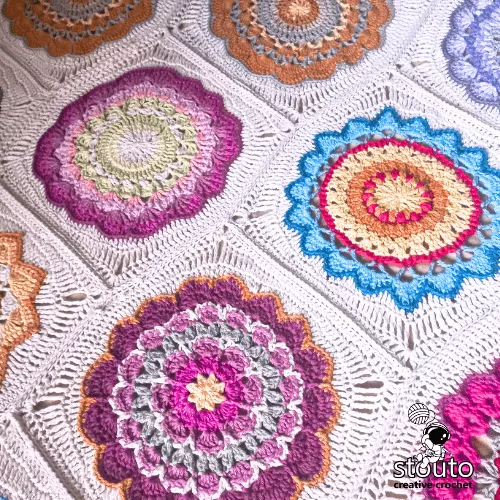 Crochet flower square blanket made with colorful DK yarn squares.