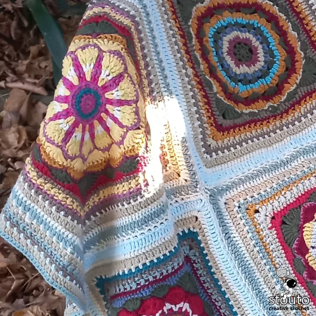 Daisy Style textured granny square crochet pattern featuring a raised flower center and decorative border.