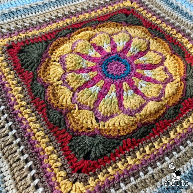 Handmade daisy granny square crocheted using double knit cotton yarn with textured floral details.