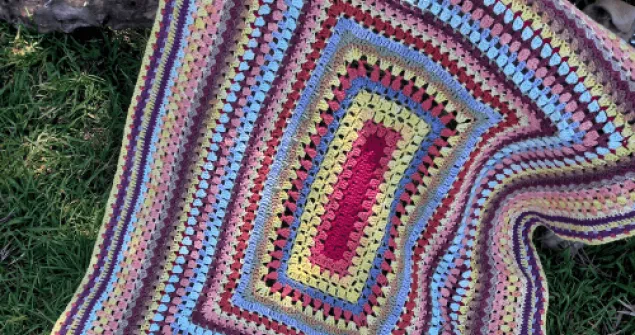 Scrap yarn baby blanket crochet pattern worked in the round using colorful leftover yarn